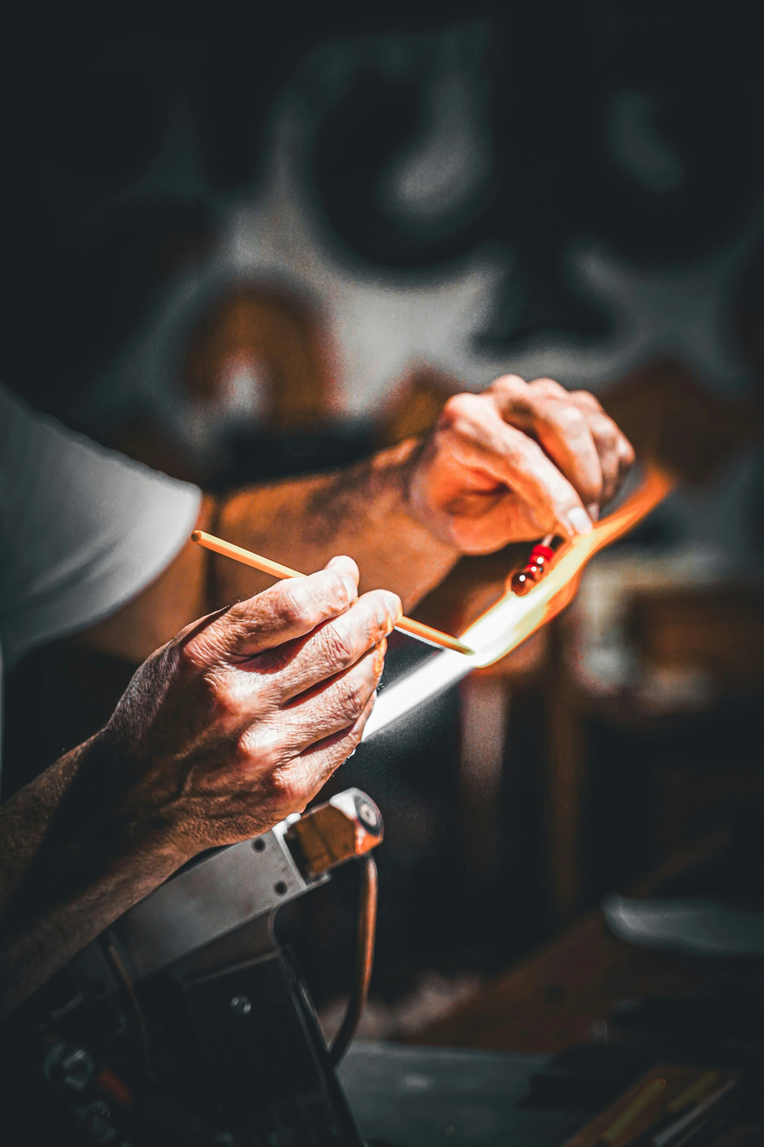 An elderly person with wrinkled hands holding a smartphone and using a stylus in a car interior.