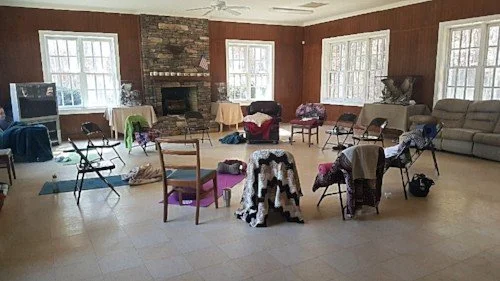 A room with chairs arranged in a circle with blankets and yoga mats from a Silent Retreat.