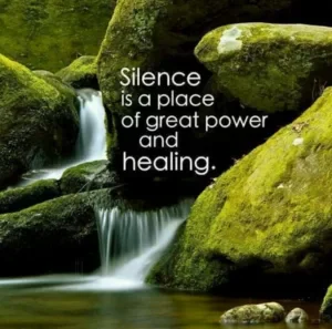A serene nature scene with a gentle waterfall flowing over moss-covered rocks, accompanied by the inspirational quote, 'Silence is a place of great power and healing.'