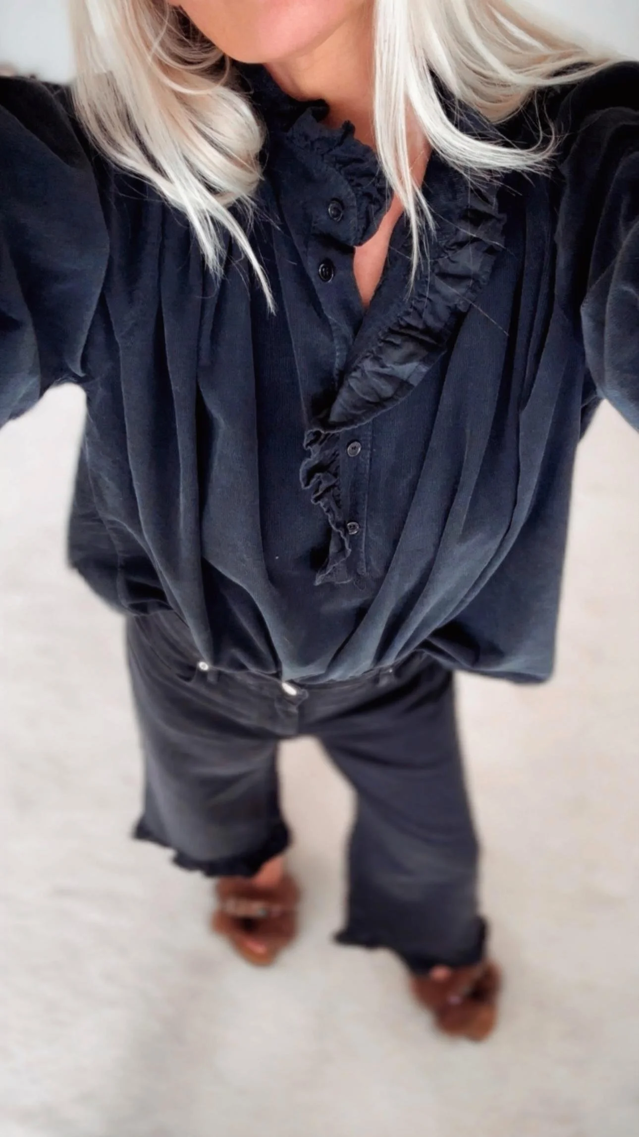 Black fine corduroy ruffle blouse with soft texture and feminine detailing.