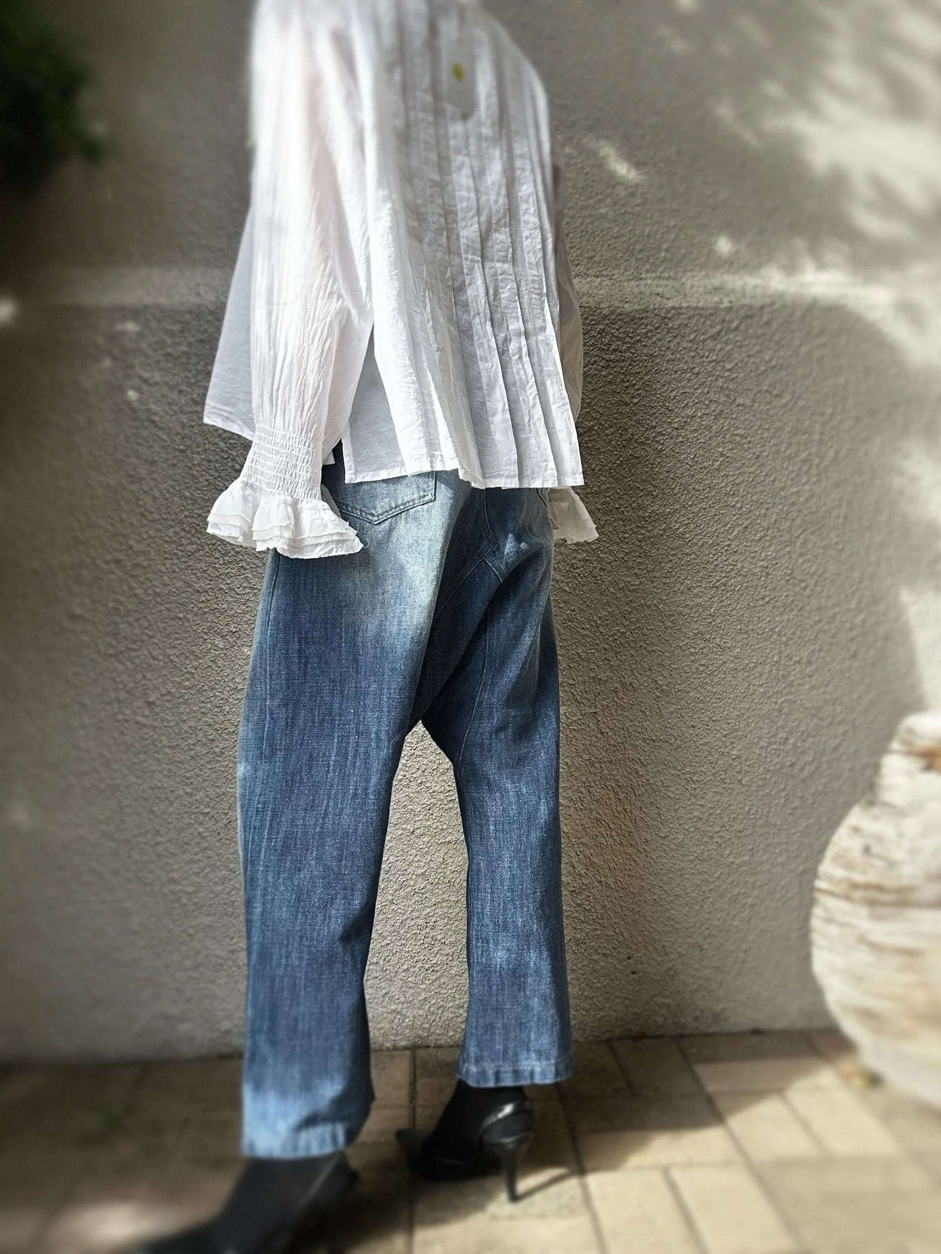 Side view of Banditas Baldwin Harem Jeans with a dropped crotch and narrower leg, styled with a loose blouse.