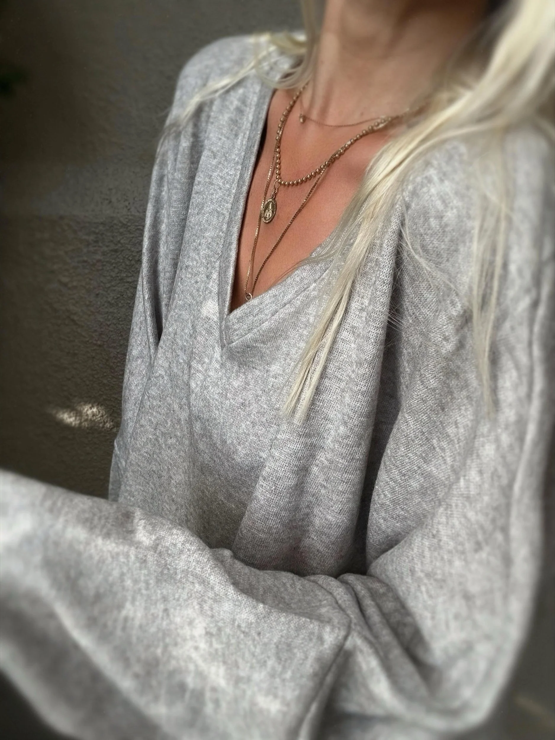 Close-up of grey Banditas Haiku Sweatshirt showing its V-neckline and textured fabric