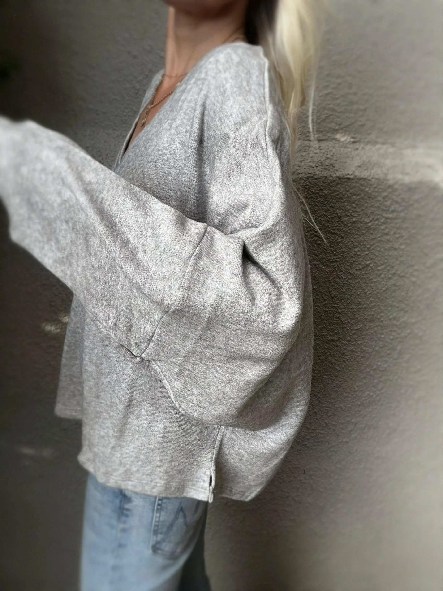 Side view of grey Banditas Haiku Sweatshirt showing its oversized sleeve and relaxed fit