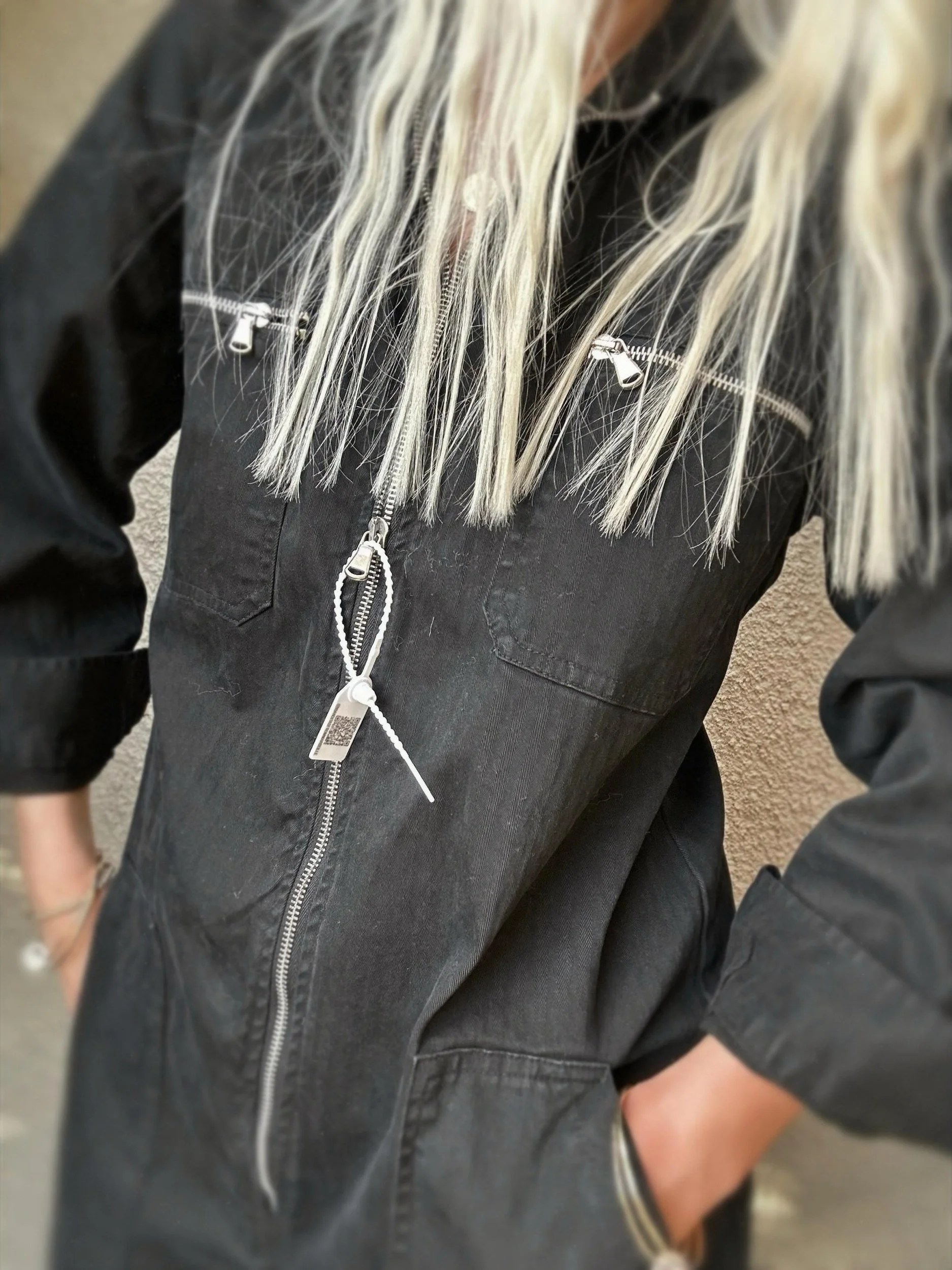 Close-up of black Banditas Hana Jumpsuit showing its front zipper and utility-inspired detailing