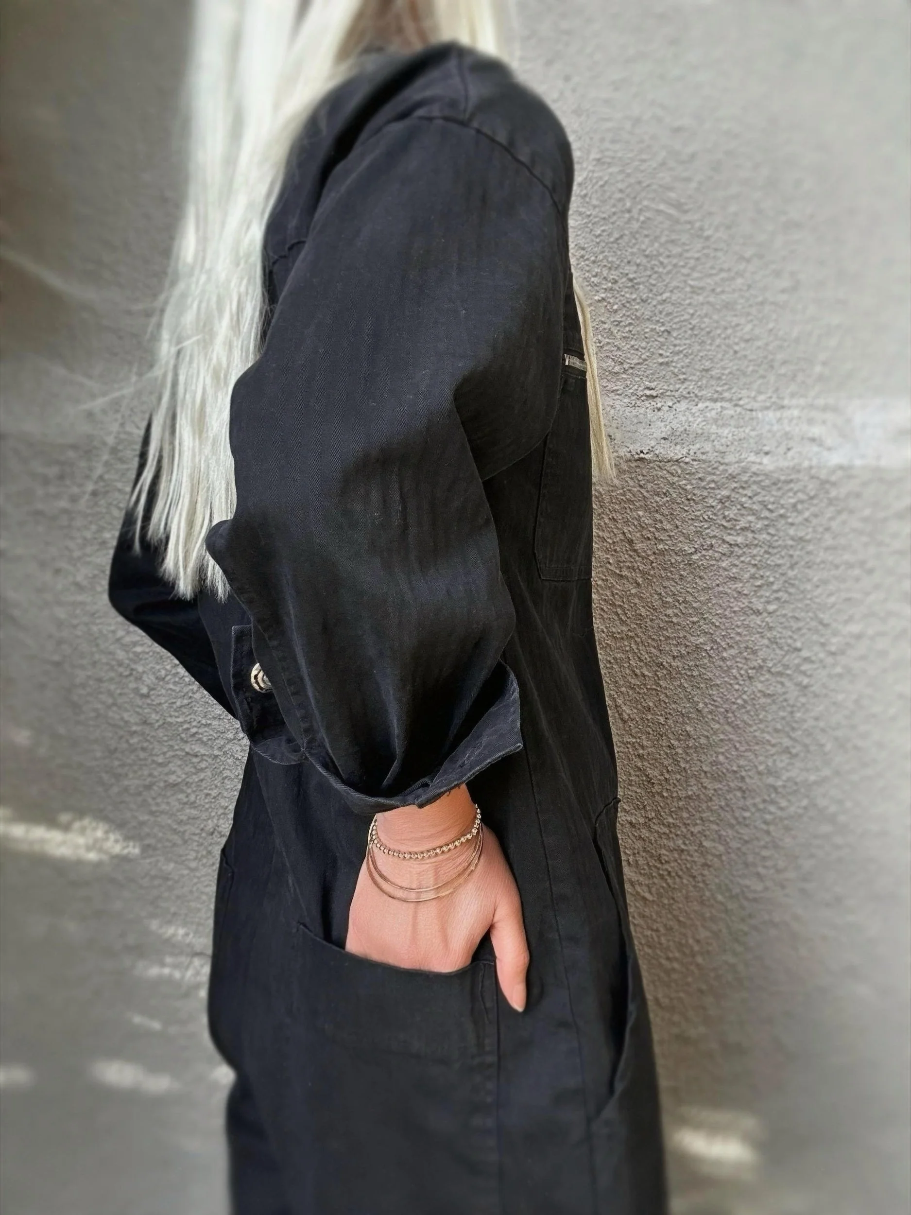 Side detail of black Banditas Hana Jumpsuit showing the sleeve cuff and pocket
