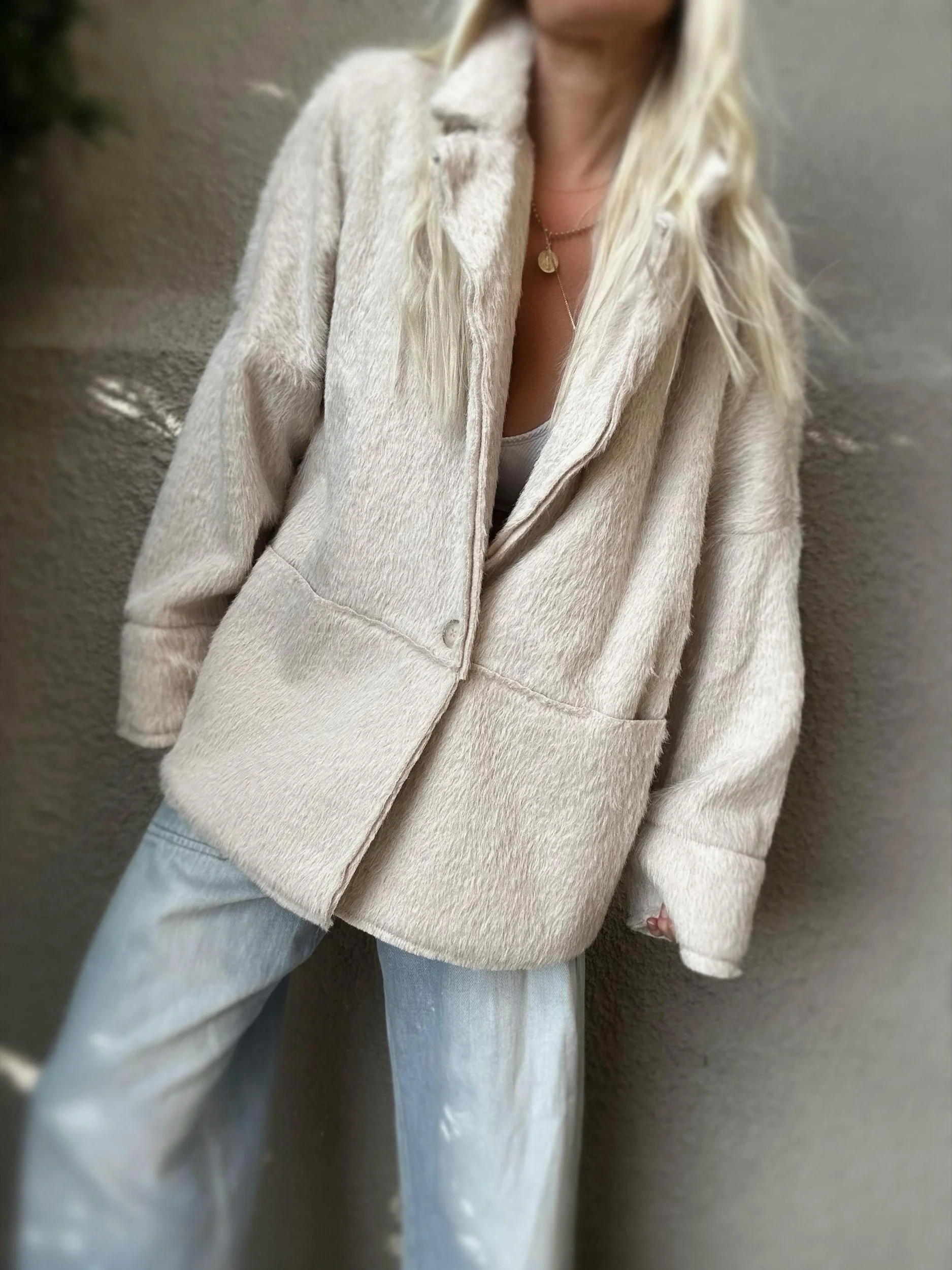 Woman wearing the cream Banditas Napili LOVE Jacket open over jeans