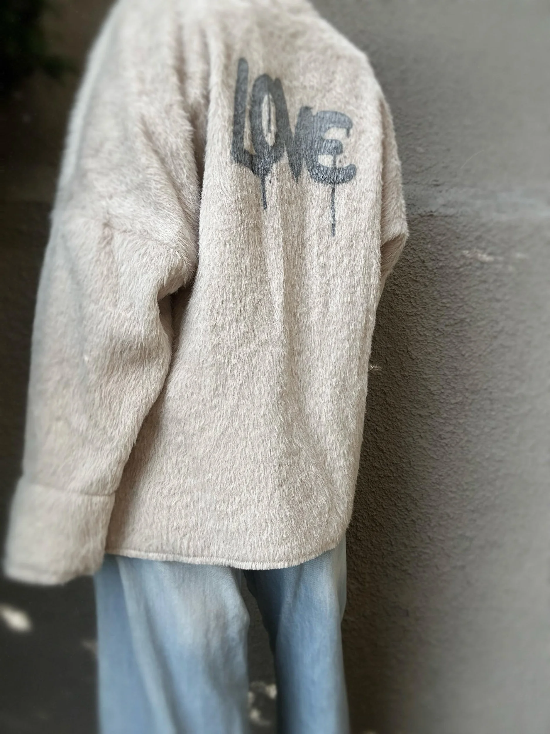 Side view of cream Banditas Napili LOVE Jacket showing the grey LOVE graphic and relaxed fit