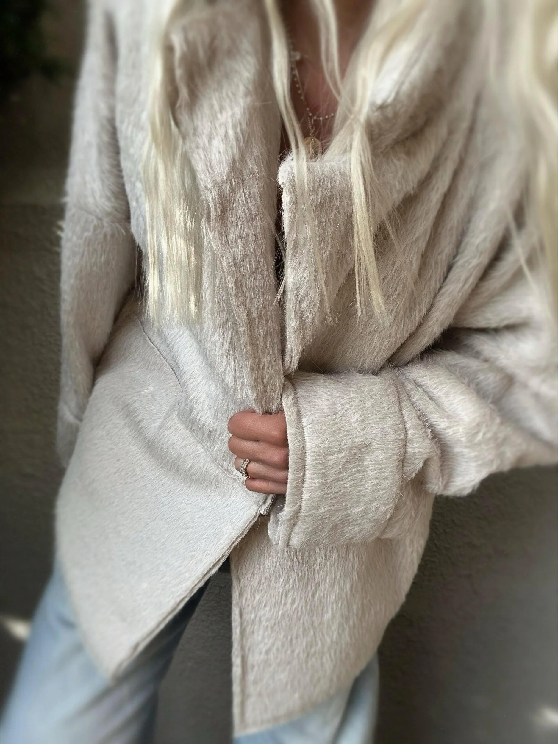 Woman wearing the cream Banditas Napili LOVE Jacket with oversized sleeves and plush fabric