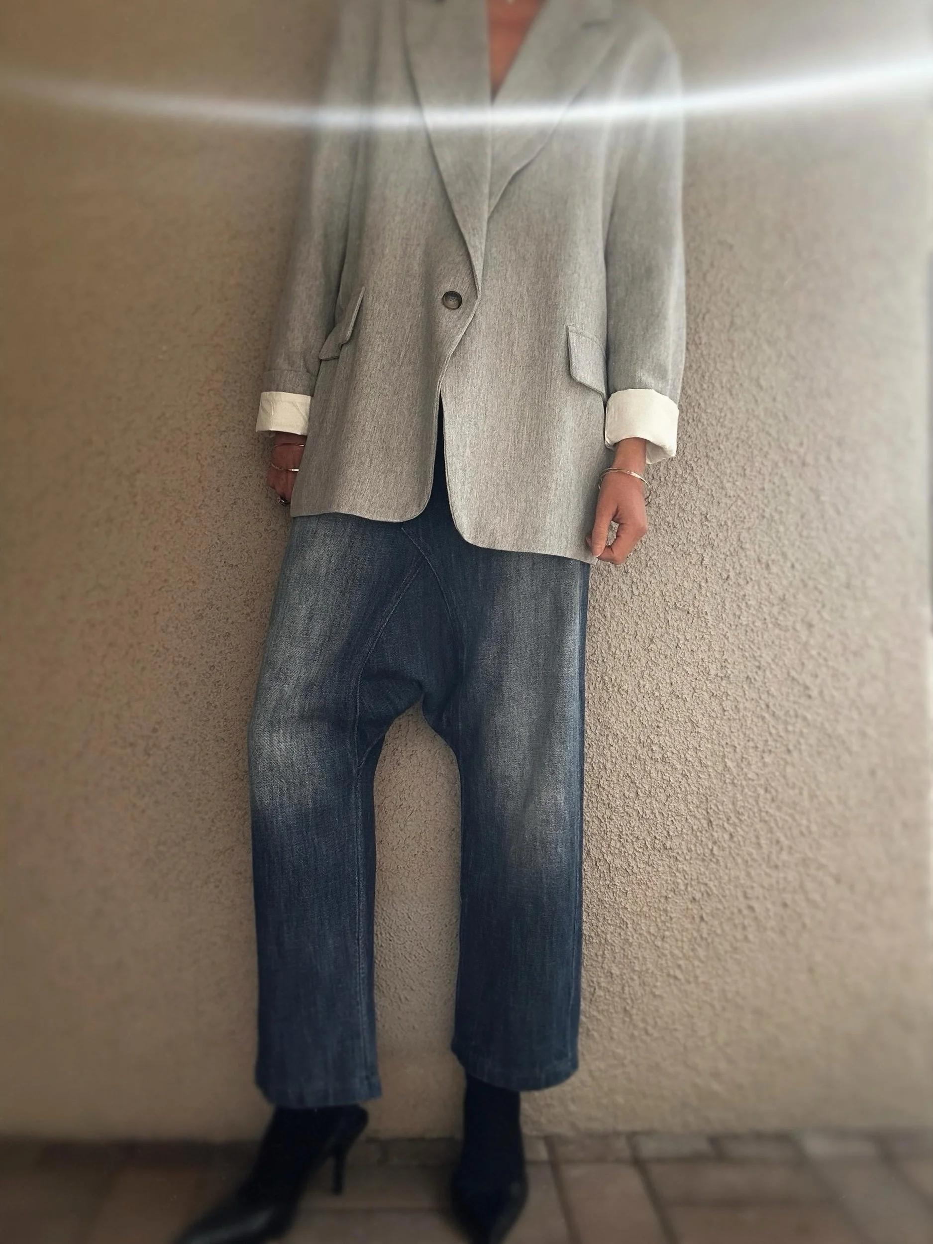 Woman styling the oversized grey Banditas Wailea Blazer with blue jeans and rolled cuffs
