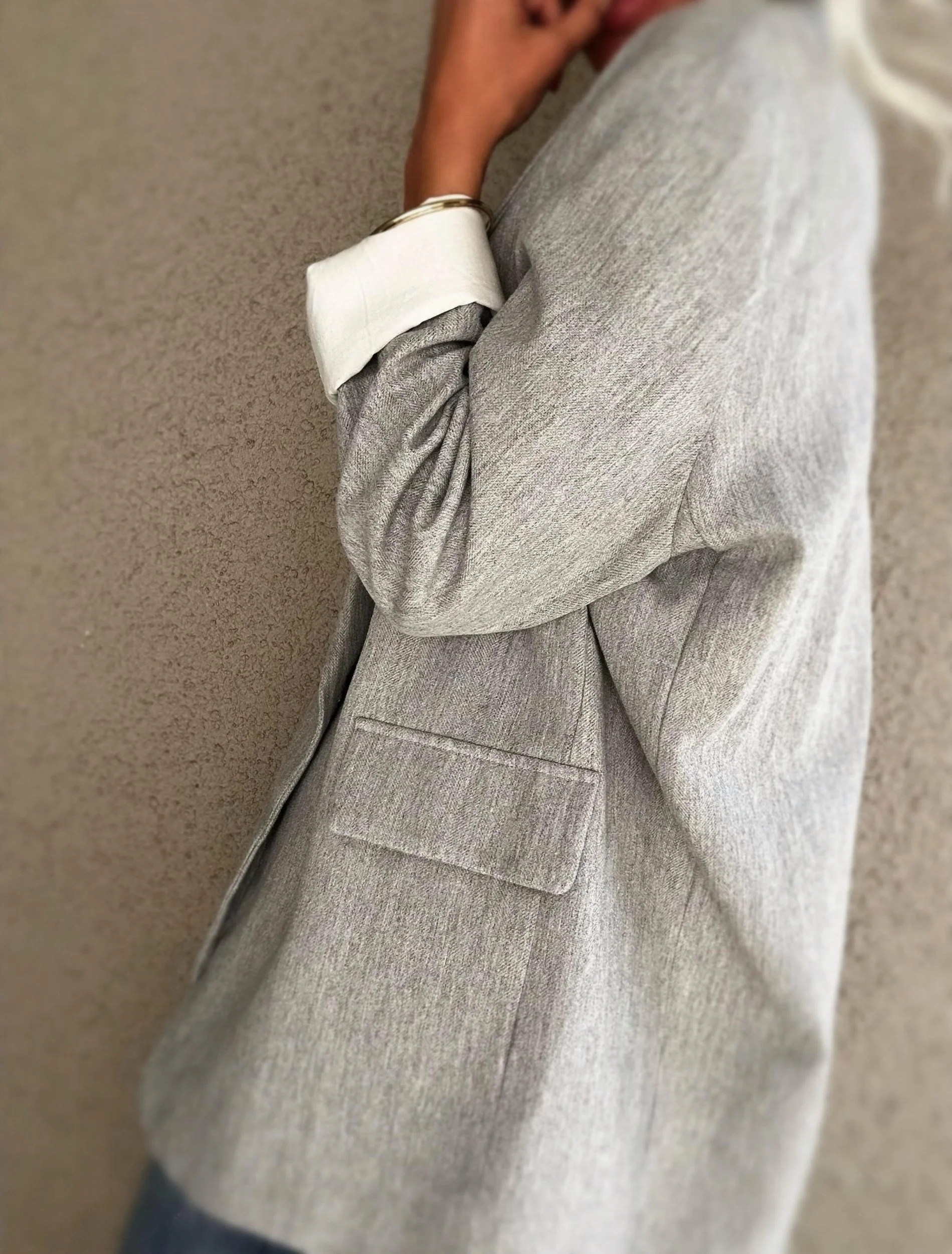 Side view of grey Banditas Wailea Blazer highlighting its rolled sleeve and contrasting white cuff