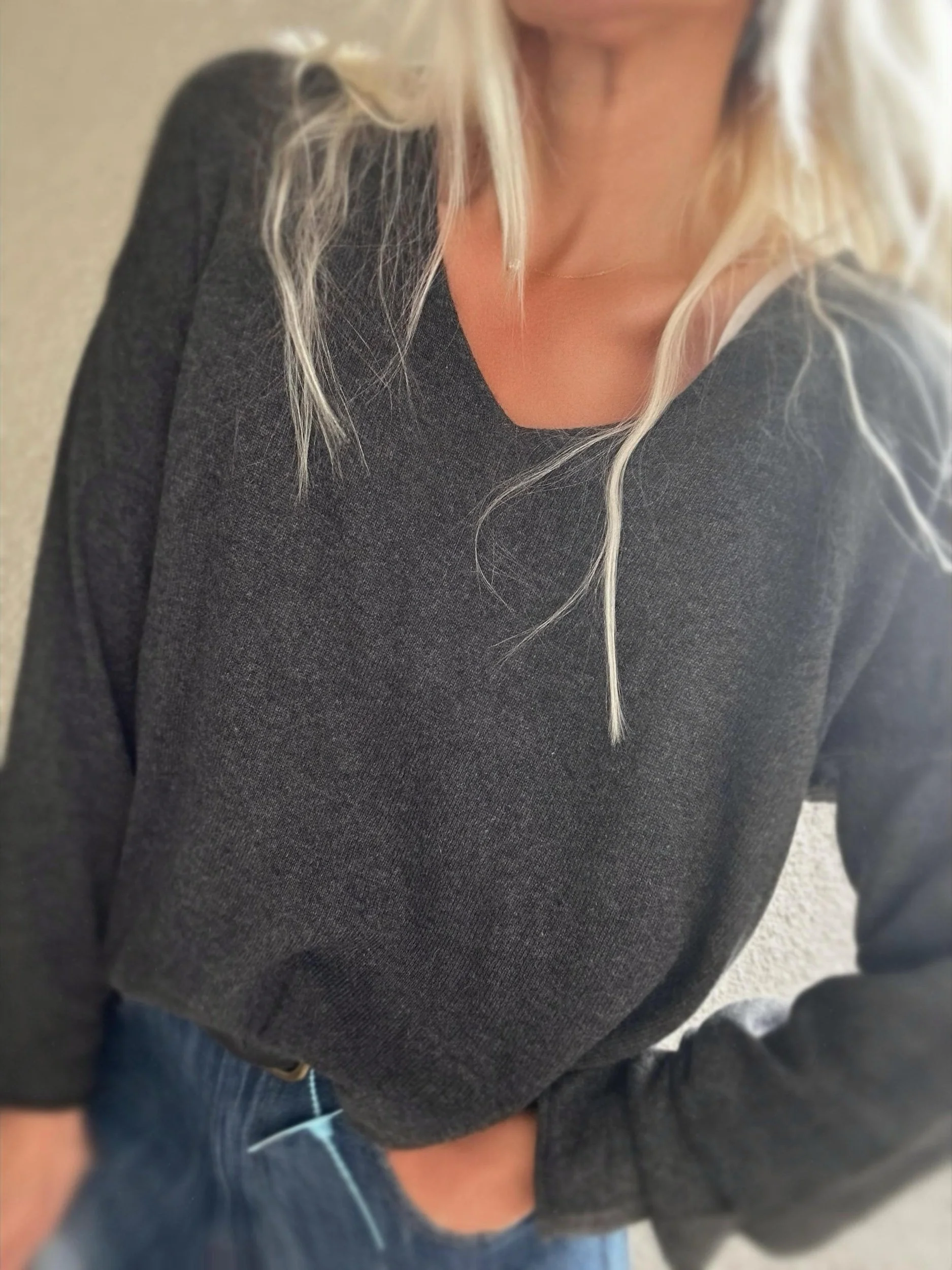 Woman wearing the charcoal grey Banditas Haleakala Sweater with relaxed fit and V-neckline
