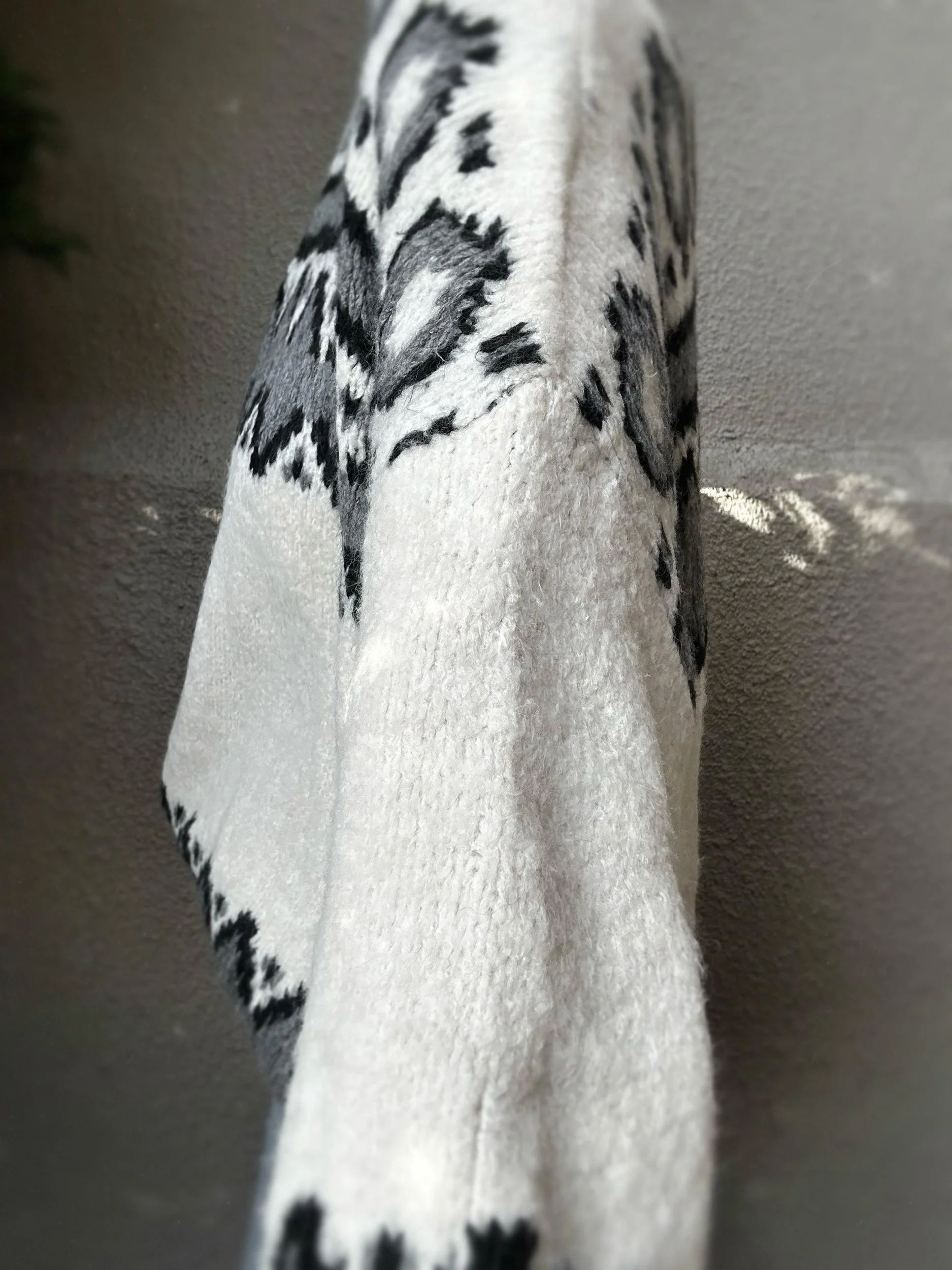 Side view of Coastal Thread Makawao Sweater cream with black worn with jeans