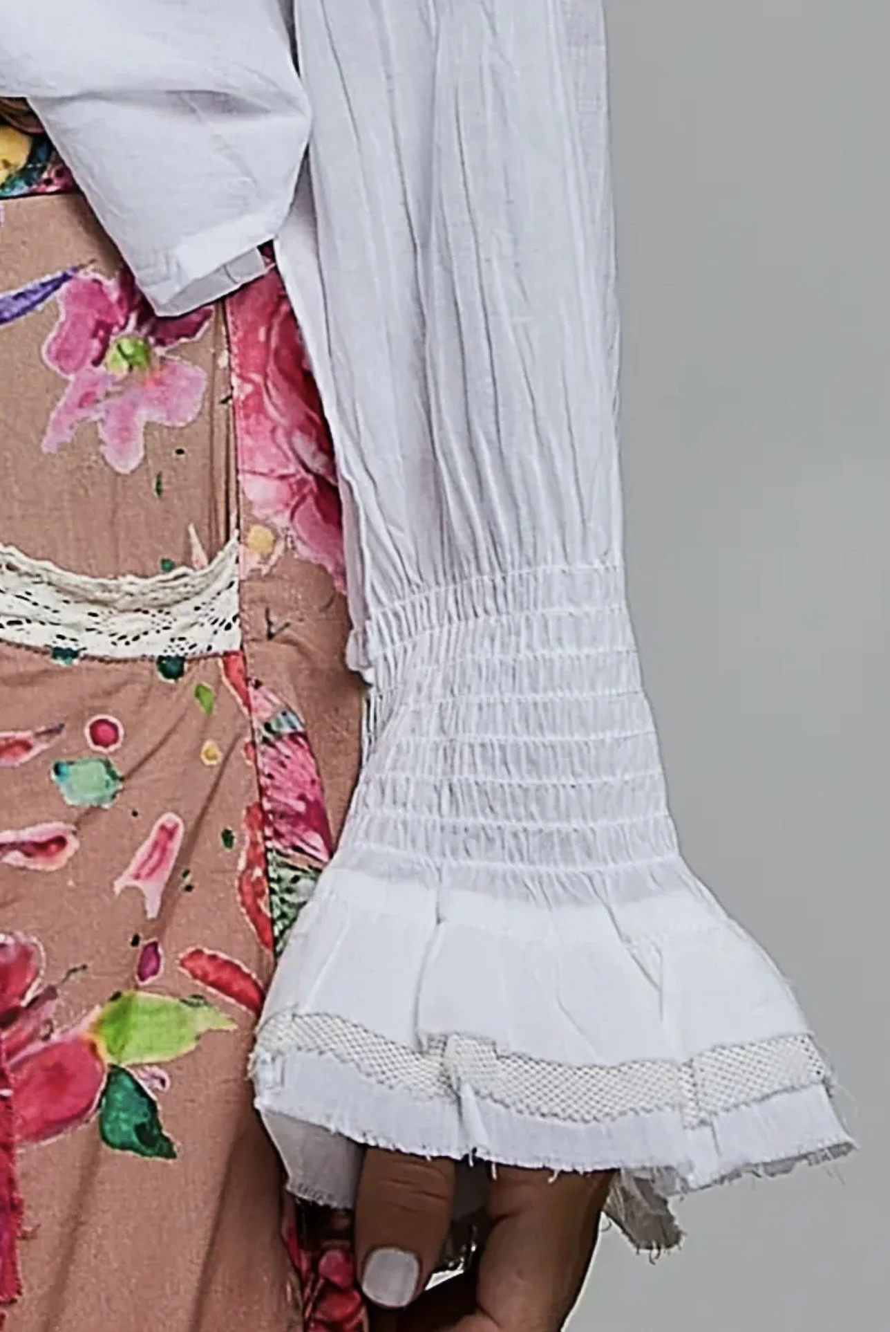 Close-up of the white blouse’s gathered sleeve cuff and flared edge.