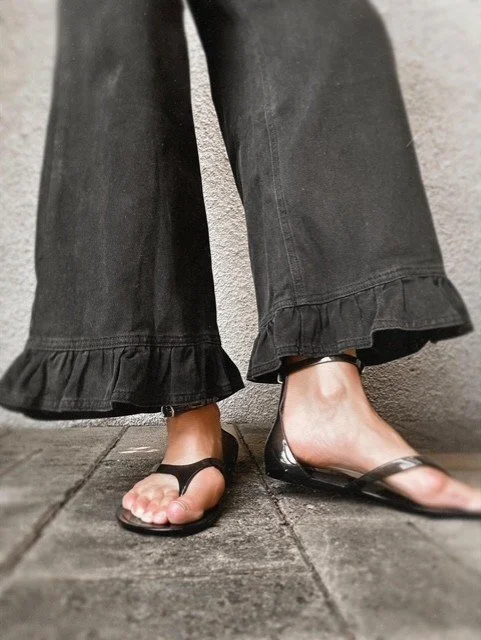 Women’s black jeans featuring a feminine ruffle hem detail
