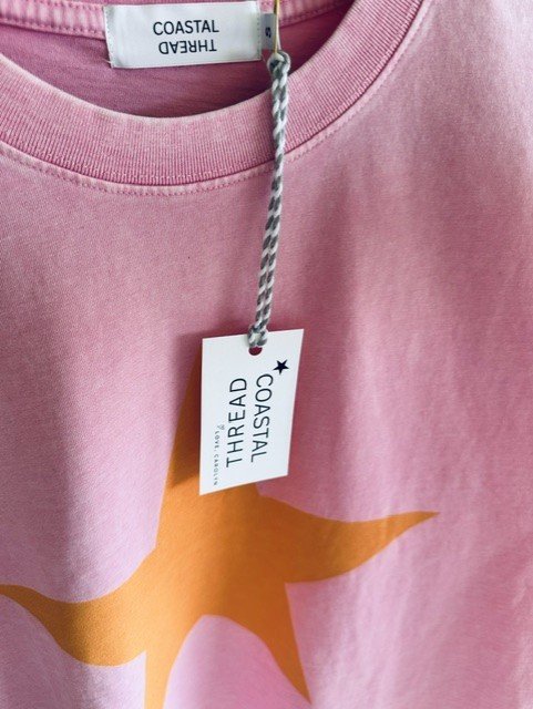 Woman wearing the Pink and Orange Star Tee styled for relaxed everyday coastal living