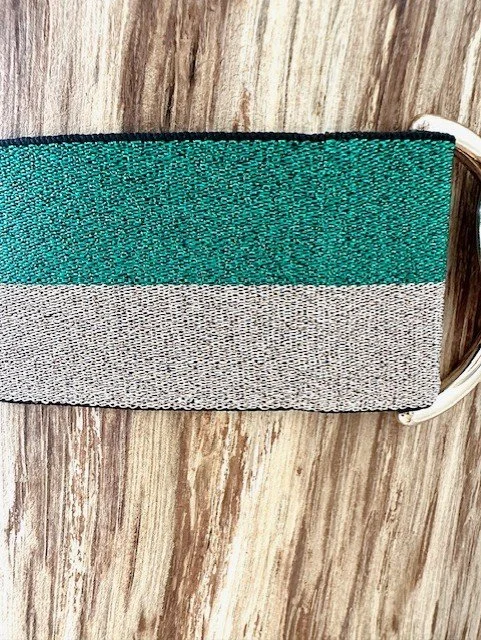 Close-up of women's gold heart clasp belt with green ribbon detail