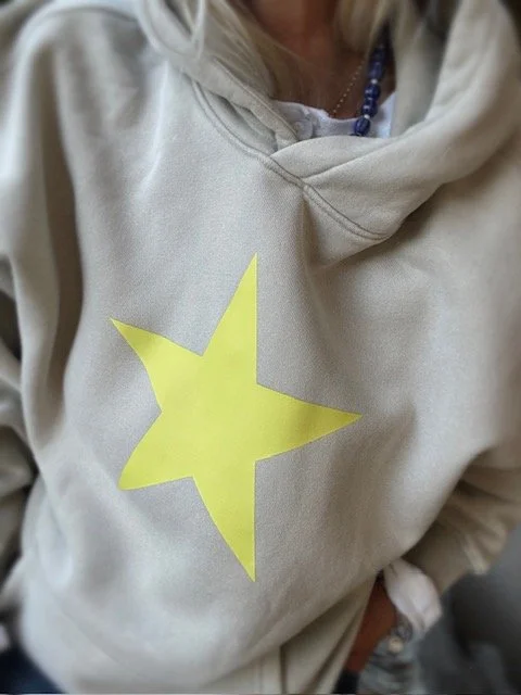 Back view of cream women's star hoodie with relaxed oversized silhouette