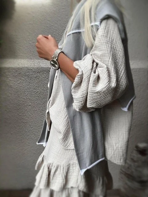 Close front view of the Wren Long Sleeve Knit in grey showing the soft hand feel, front seam detail, and white-bound hem.