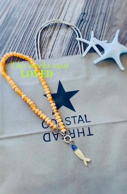 Beaded yellow and orange fish pendant necklace with Coastal Thread bag