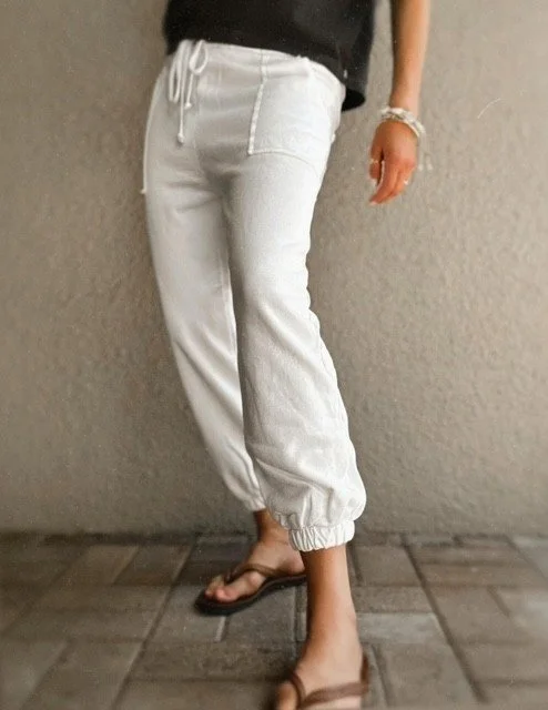 Close-up of women's white joggers with self-tie bow waistband detail