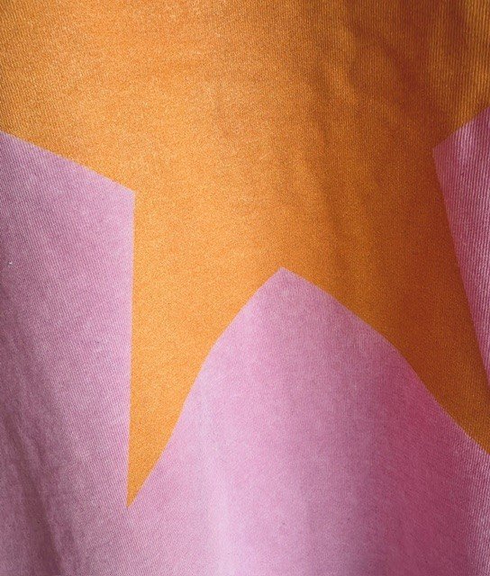 Close-up of the Pink and Orange Star Tee highlighting the mineral wash finish and soft cotton fabric