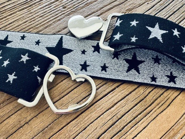 Close-up of women's silver heart clasp belt with star details