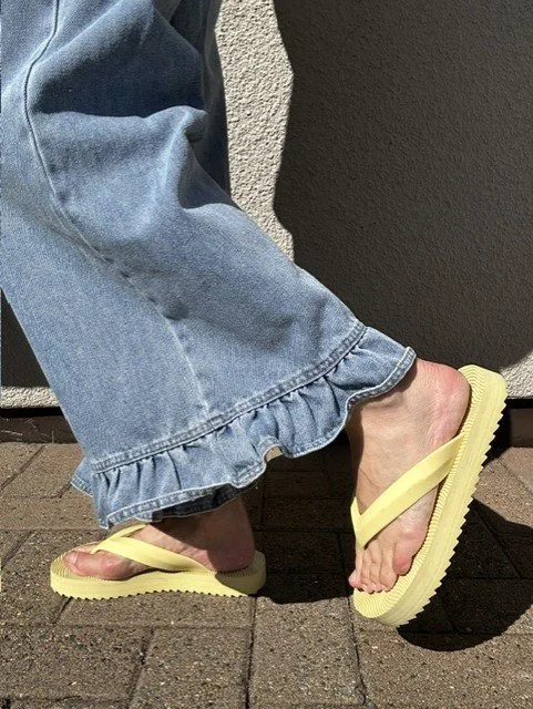 Women’s blue jeans featuring a feminine ruffle hem detail