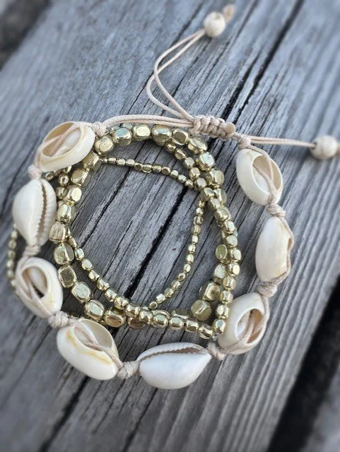 Close-up of cowrie shell bracelet with gold nugget bead details
