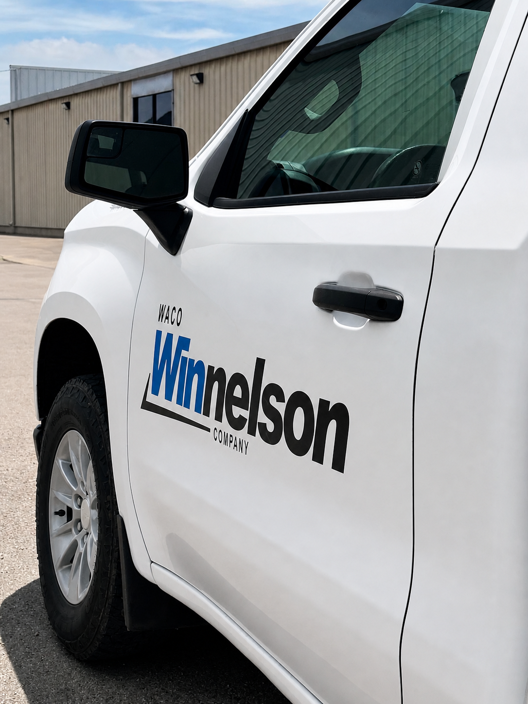 White Waco Winneson company vehicle with black and blue text on the door.
