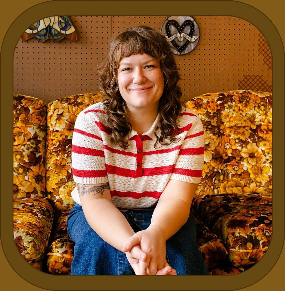 Margie Ewald sitting on a 70s-floral-pattern couch.