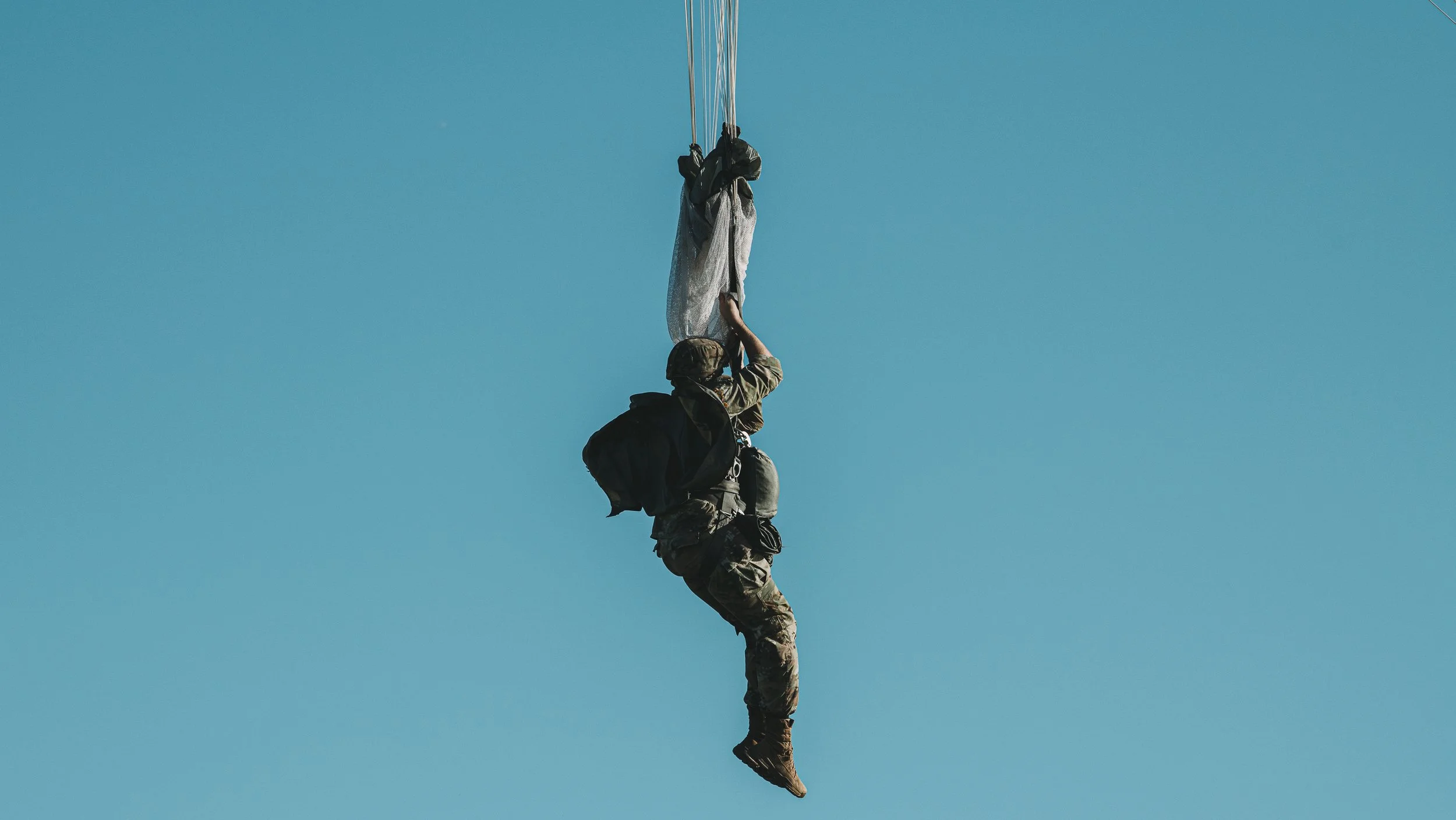Paratrooper on a line against the sky