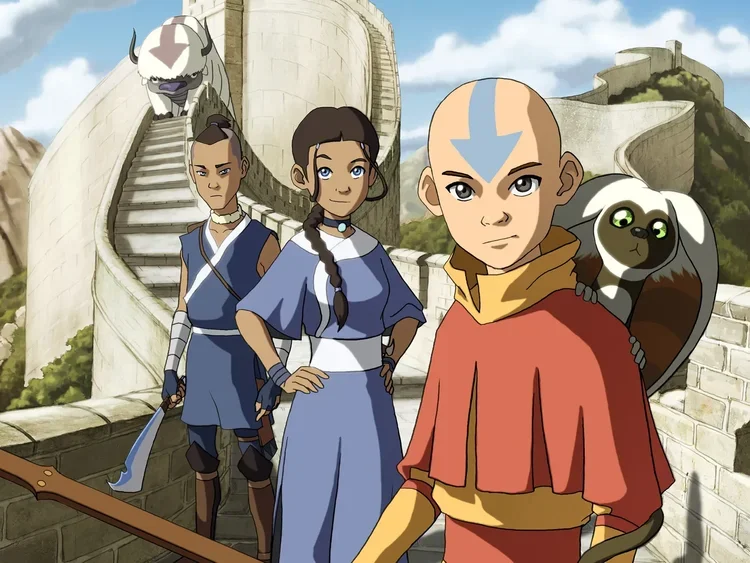 Group of four characters from 'Avatar: The Last Airbender' standing outdoors on a stone wall, with a large white animal on the wall and a giant creature on the stairs in the background.