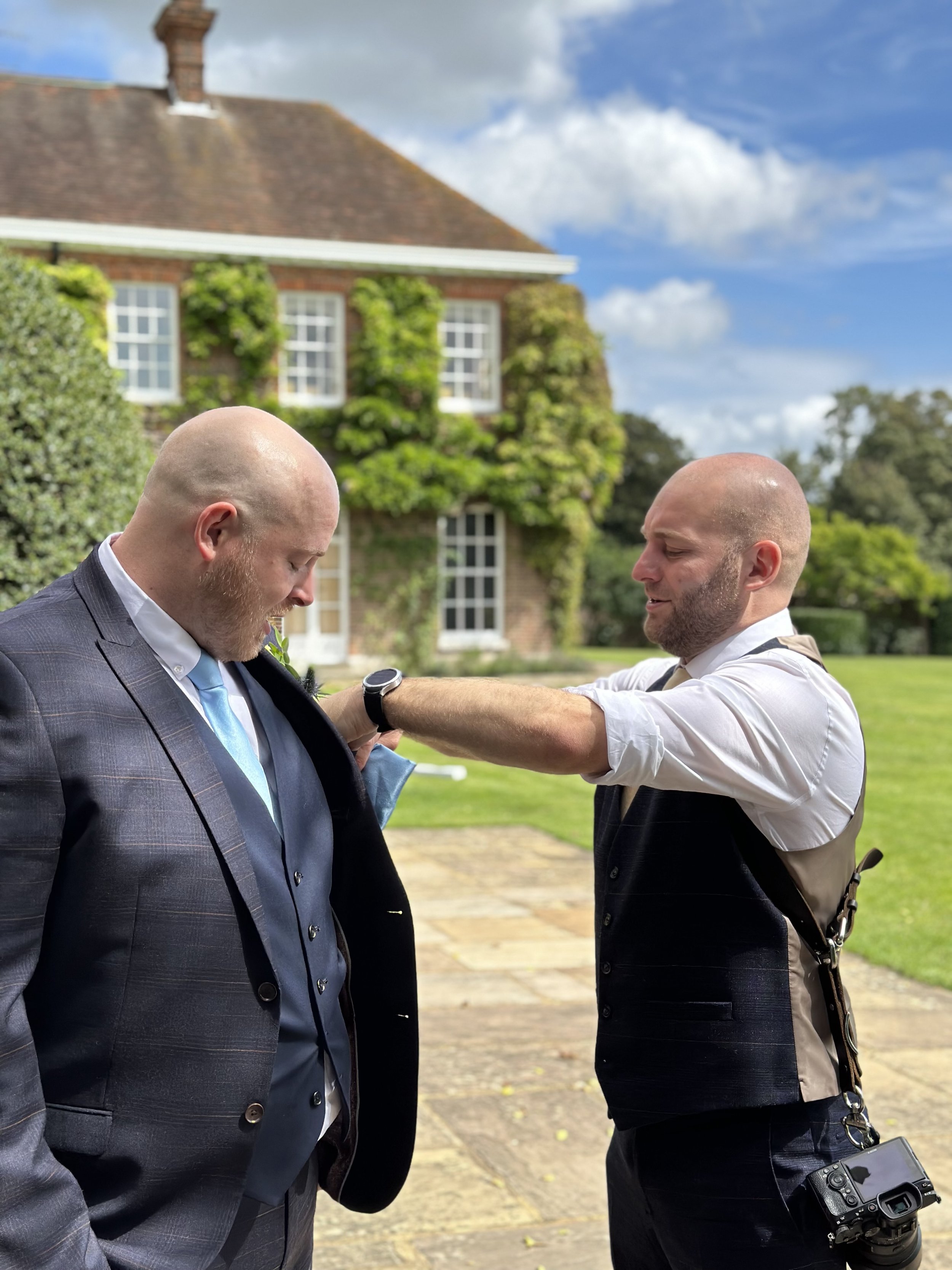 Lewis Horsley adjusting a pocketsquare on a groomsman