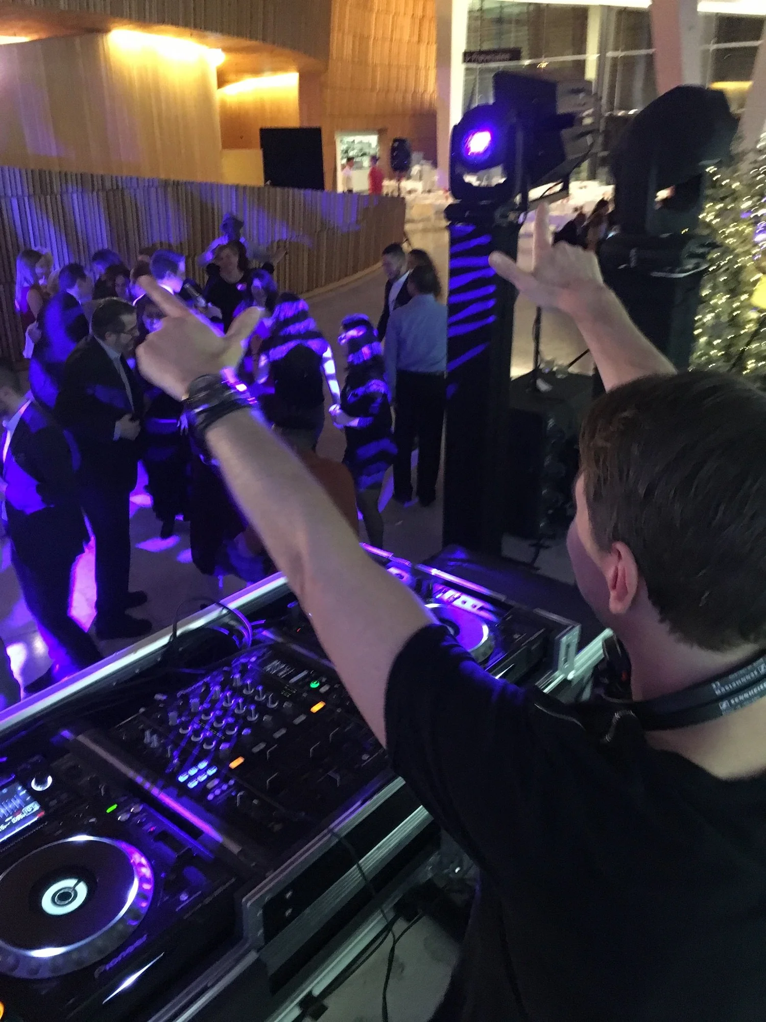 Reidar Buskenes bak DJ-pulten med armene i været under firmafest i Den Norske Opera