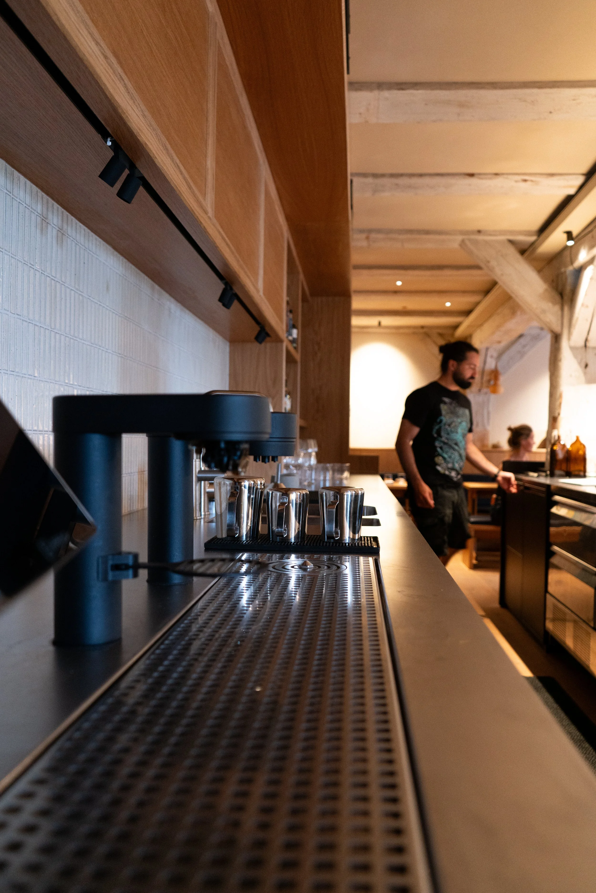 Black SPECTER coffee dispensing taps integrated into Restaurant BARR's counter with the dining area beyond.