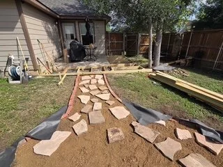 Laying down the custom stone pavers for the new walkway.