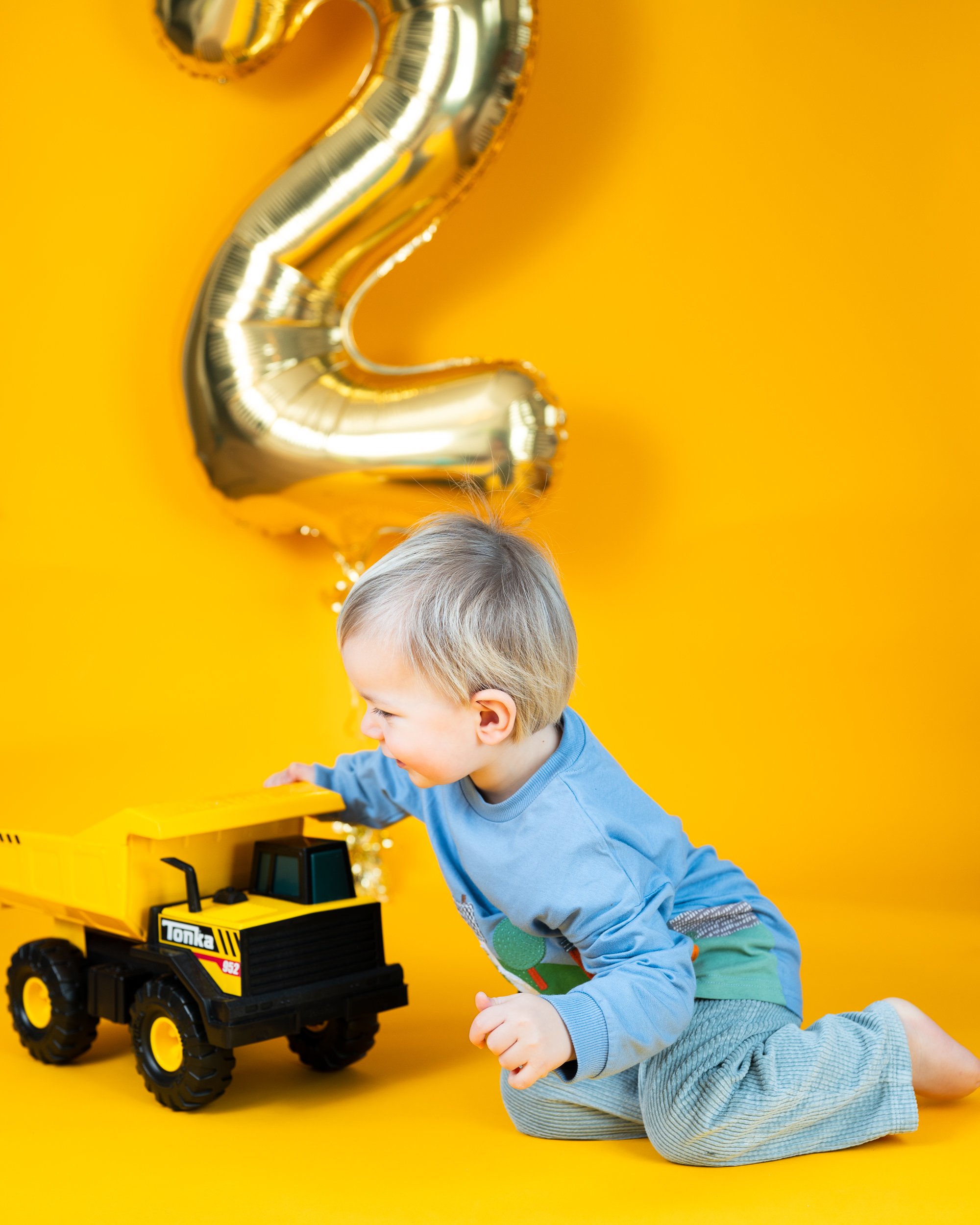 toddler in front of number 2 balloon at a birthday milestone photoshoot in worcestershire