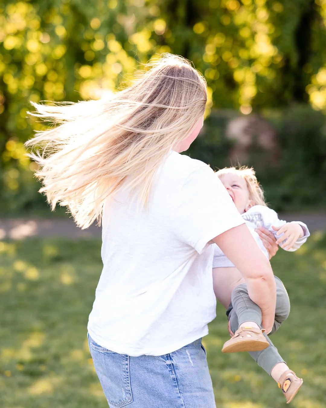outdoor family photoshoot in Worcester with mum spinning toddler.
