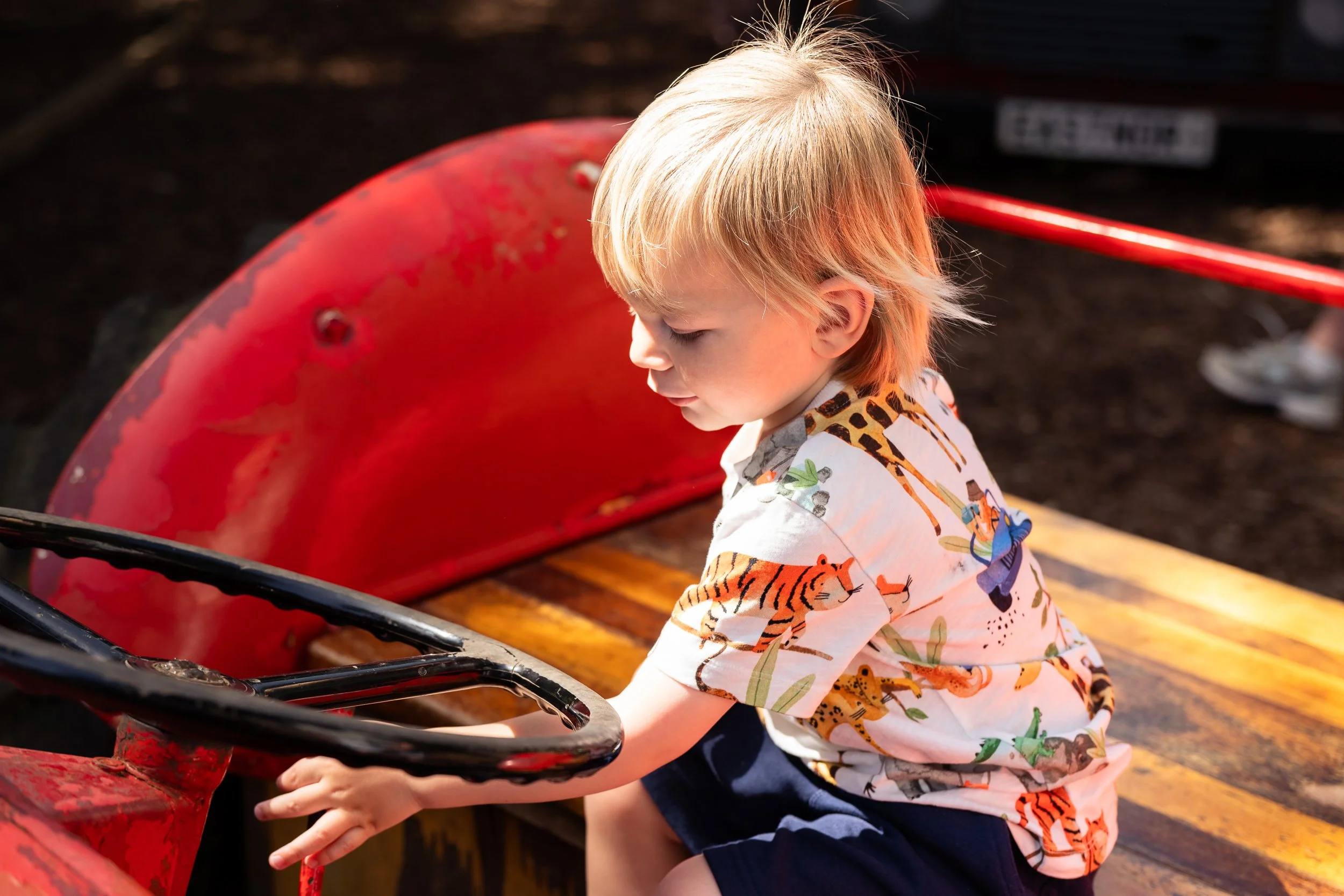 toddler sitting on red tractor during family photoshoot in hereford taken by Chloe Bower Photography the best worcester photographer