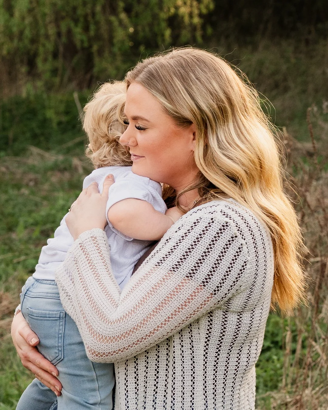 Mother holding toddler during sunset photoshoot in Droitwich