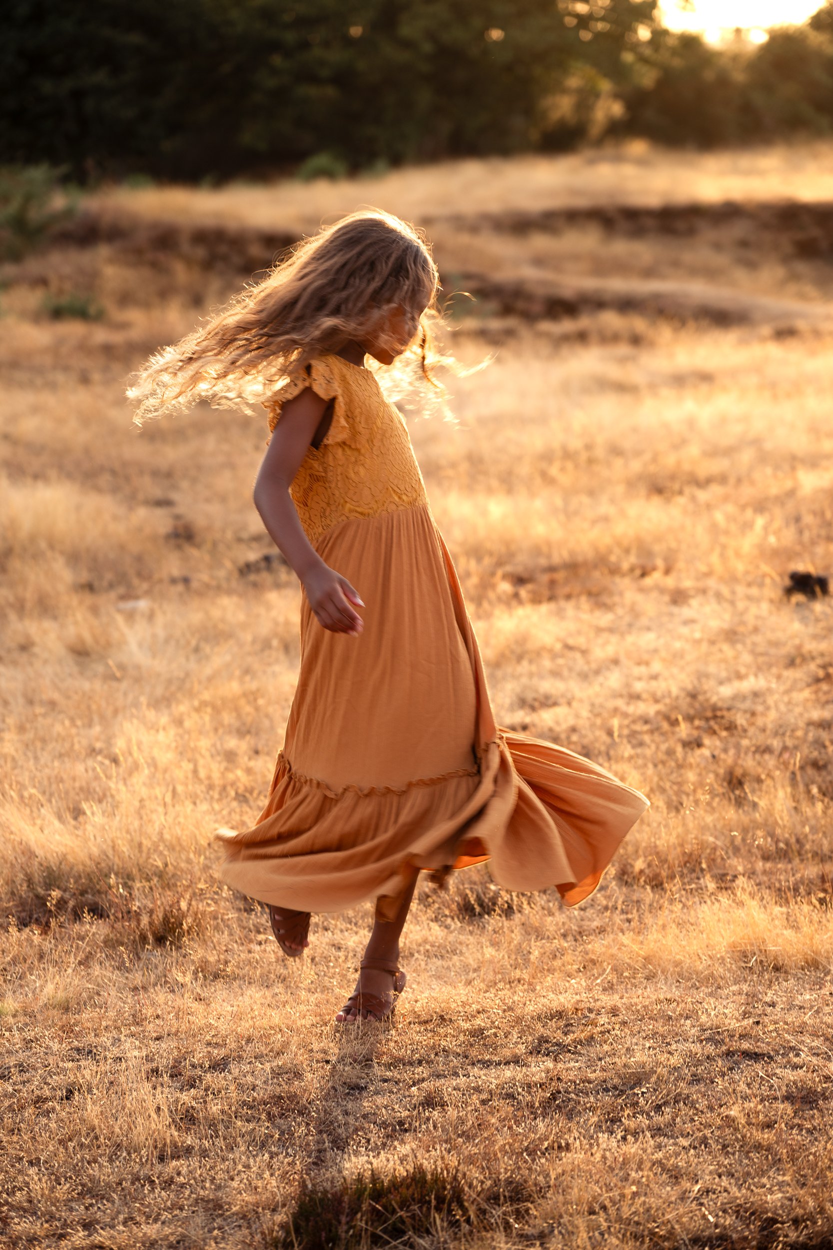 little girl tailing in yellow dress during sunset family photoshoot in worcester
