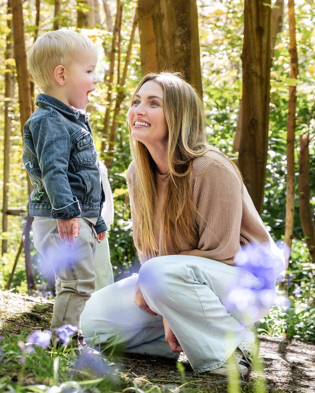 Mother looking at toddler in the bluebells
