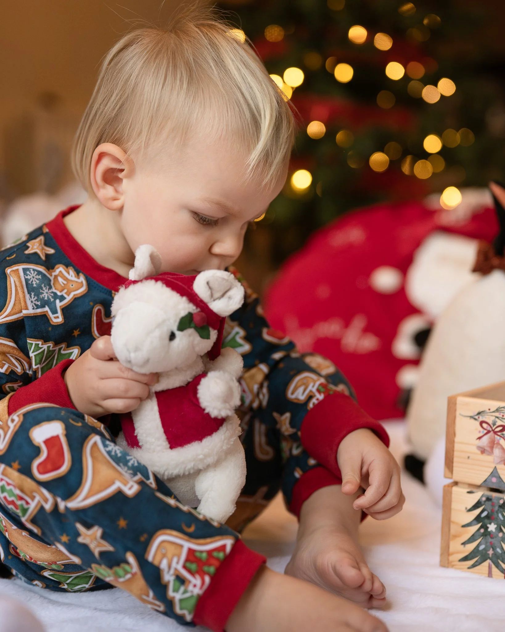 Child playing beside a Christmas tree during a Christmas at Home family photography session in Worcester