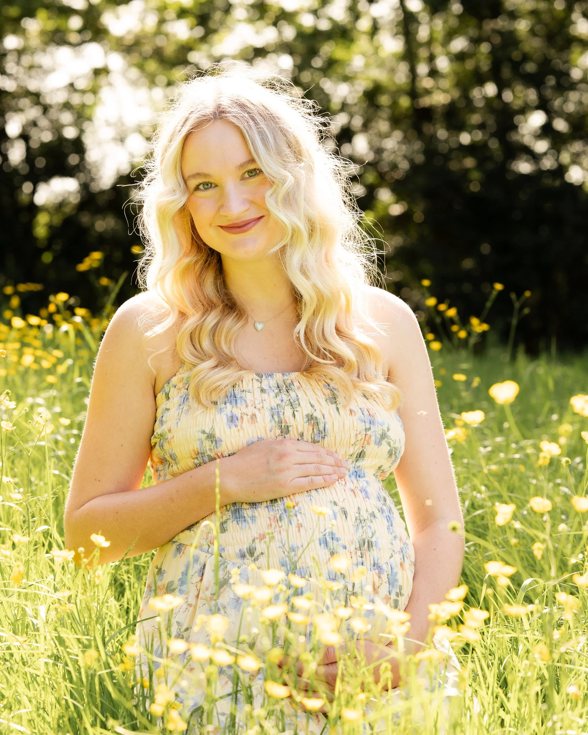 Pregnant women sitting in field of wild flowers during maternity photoshoot