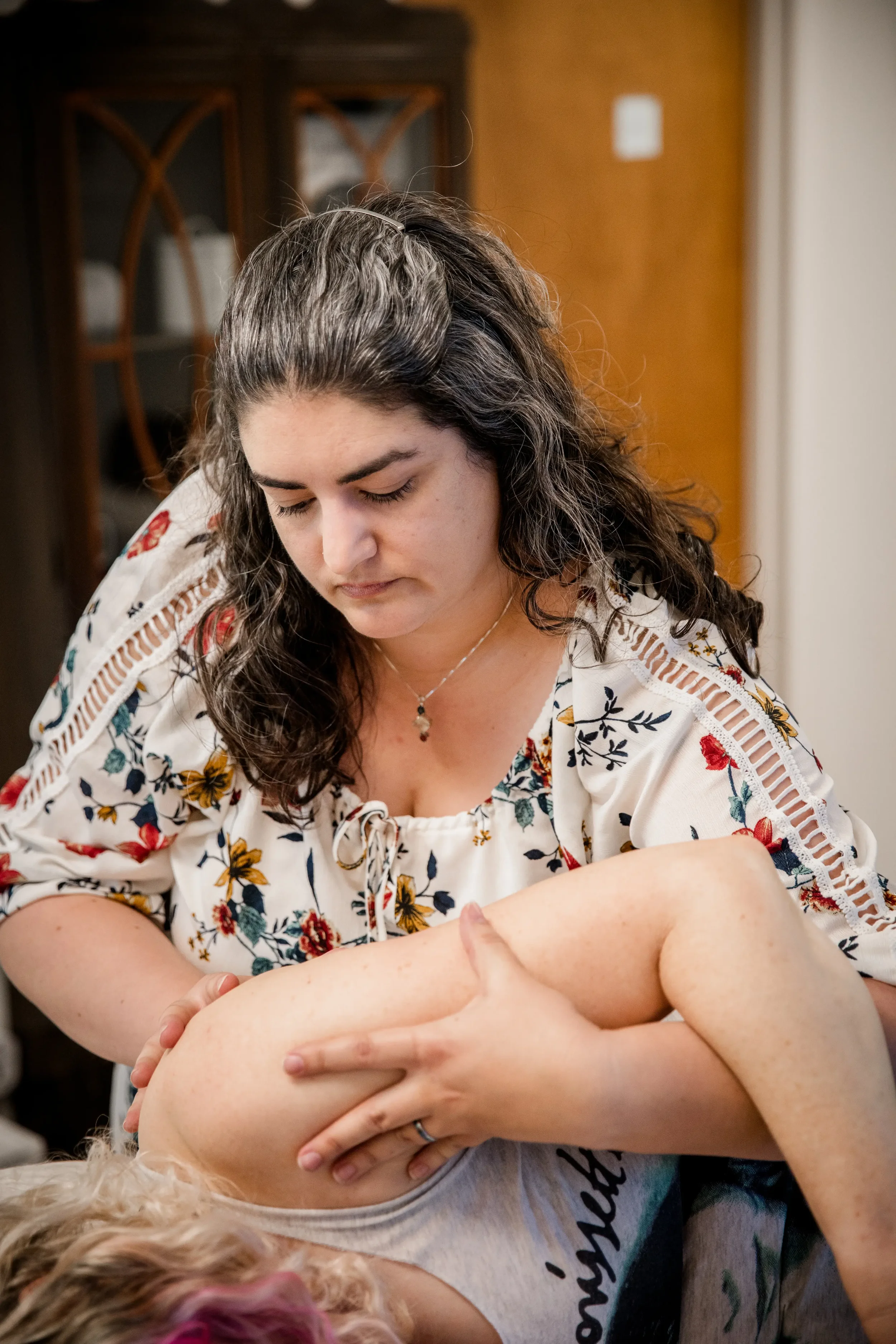 Fifi Heurlin, certified Ortho-Bionomy® practitioner, gently supporting a client's shoulder and arm during a noninvasive bodywork session in Vancouver, WA