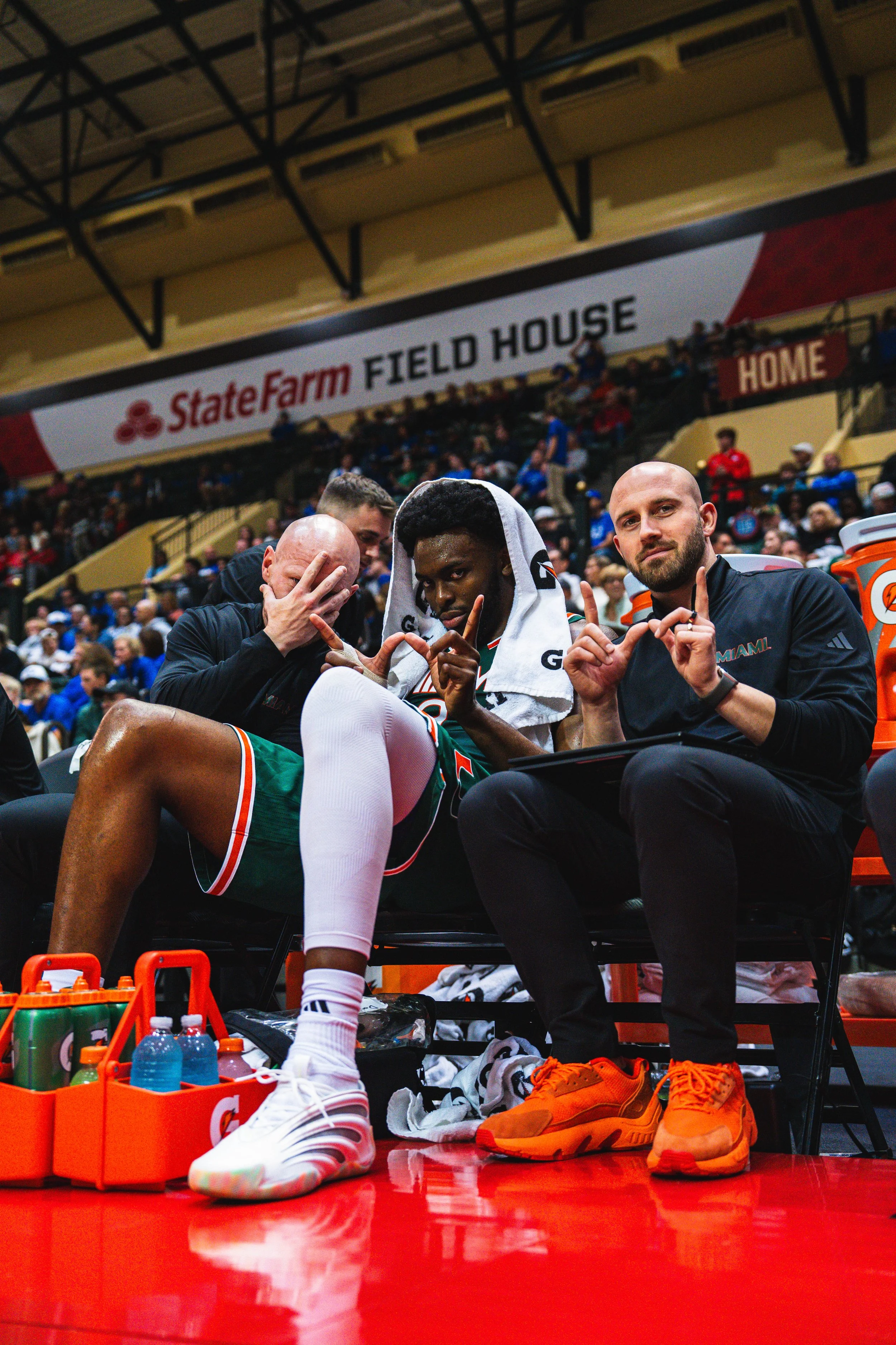 Tommy sitting courtside with staff and players.