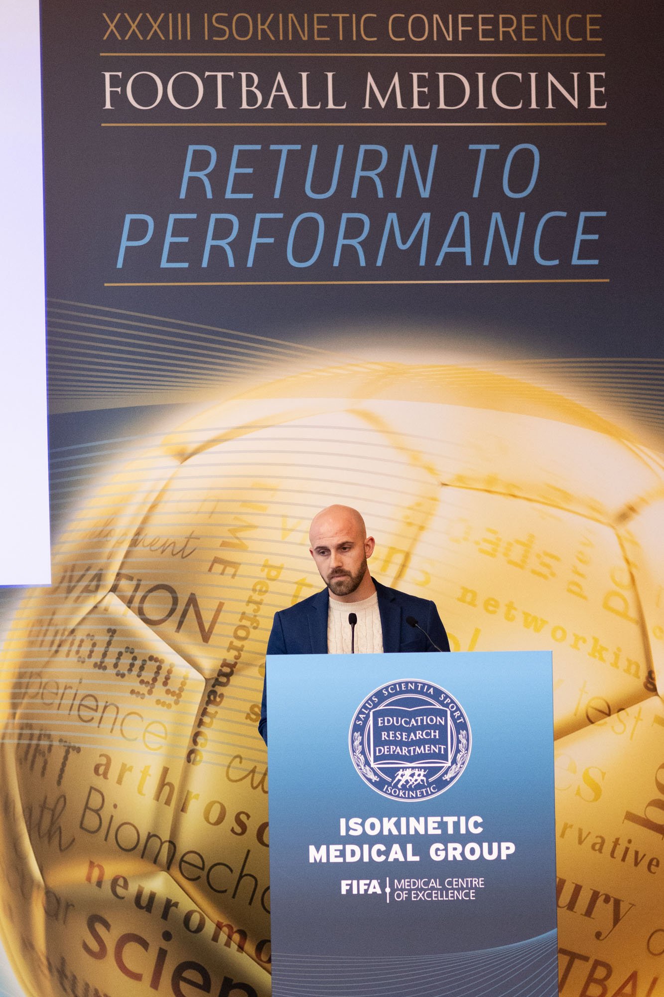 Tommy Otley speaking at the 'ISOKINETIC MEDICAL GROUP FIFA Medical Centre of Excellence' at a conference.