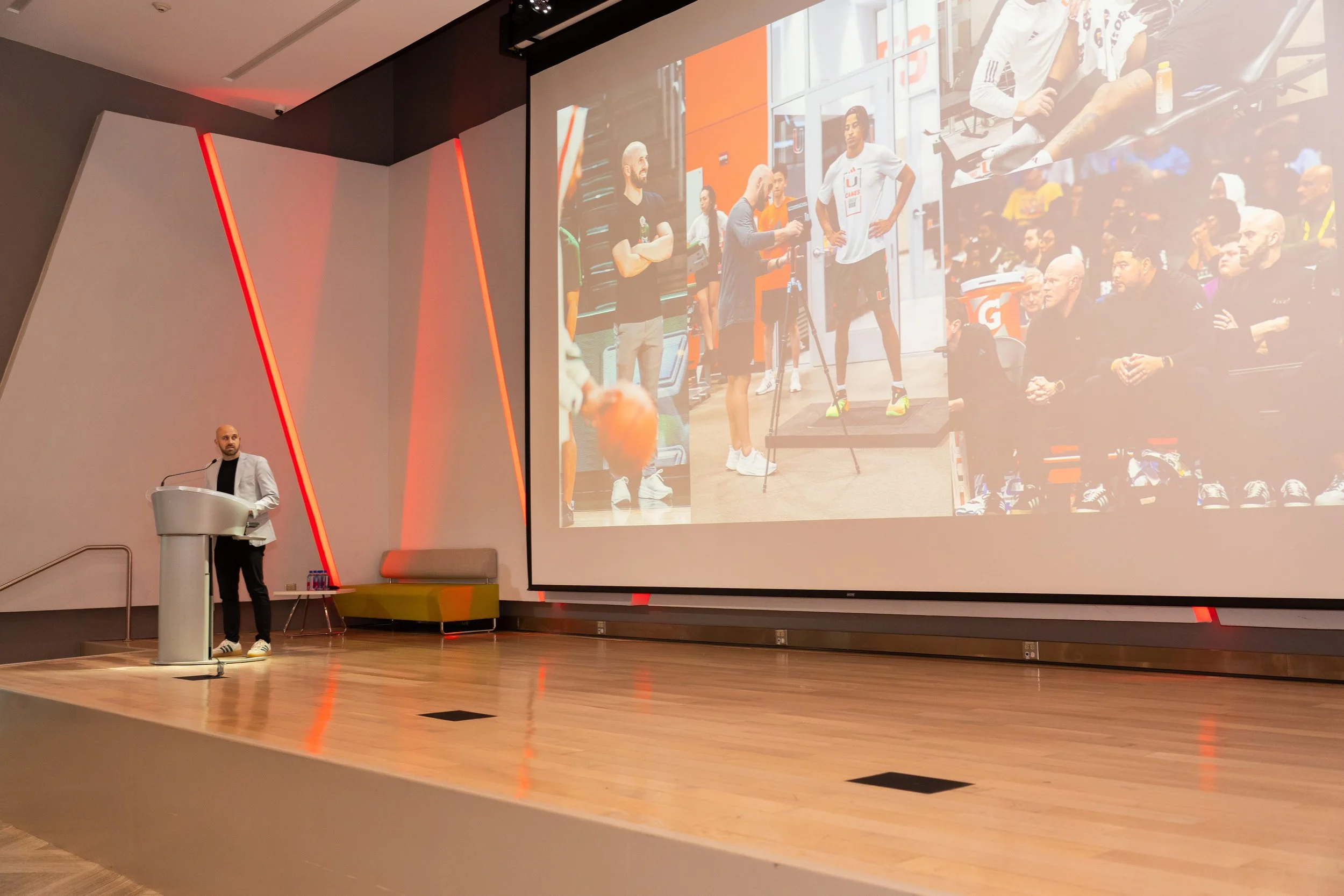 Tommy Otley giving a speaking presentation on sports science and performance metrics.