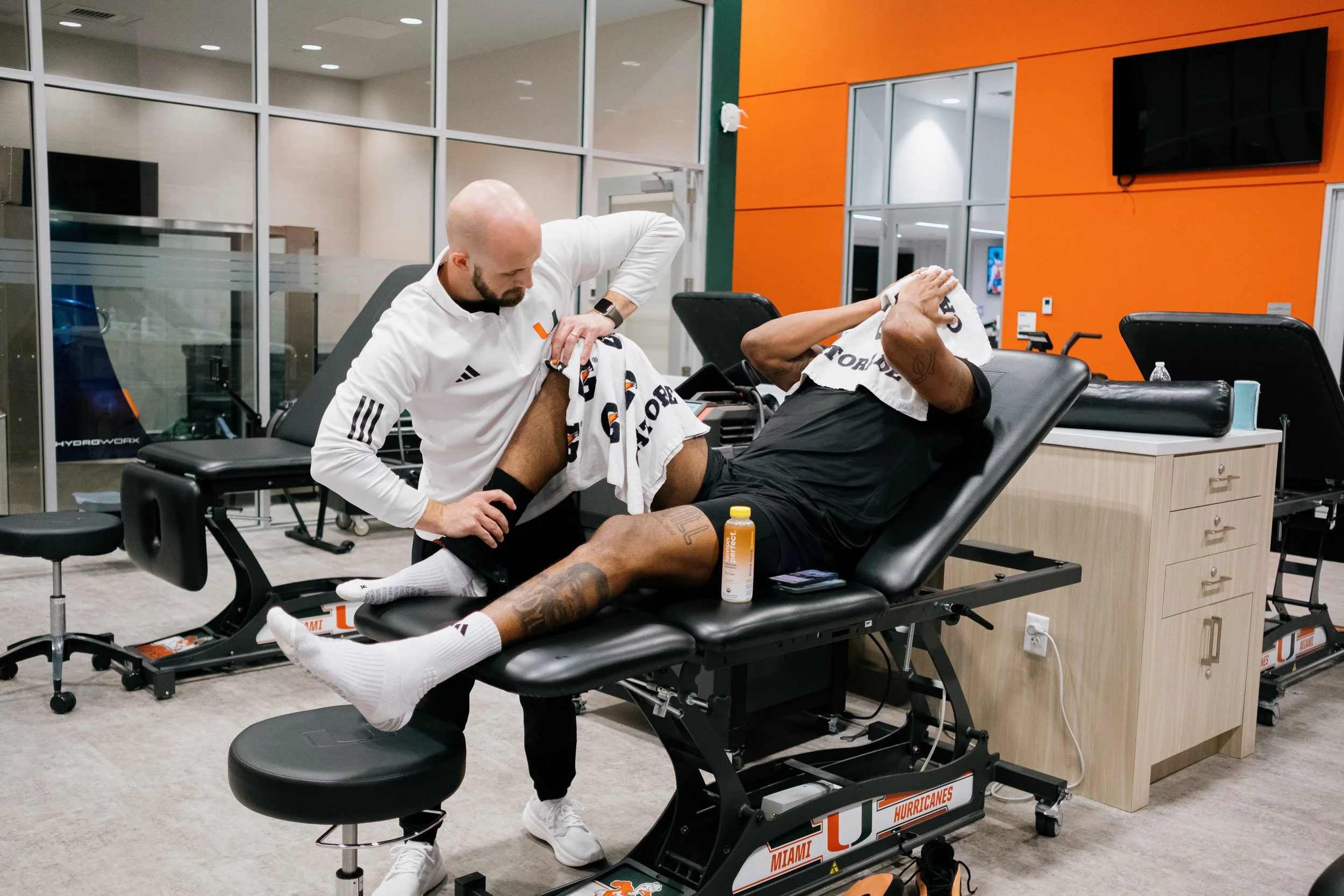Tommy Otley working with an athlete in the University of Miami training room. 