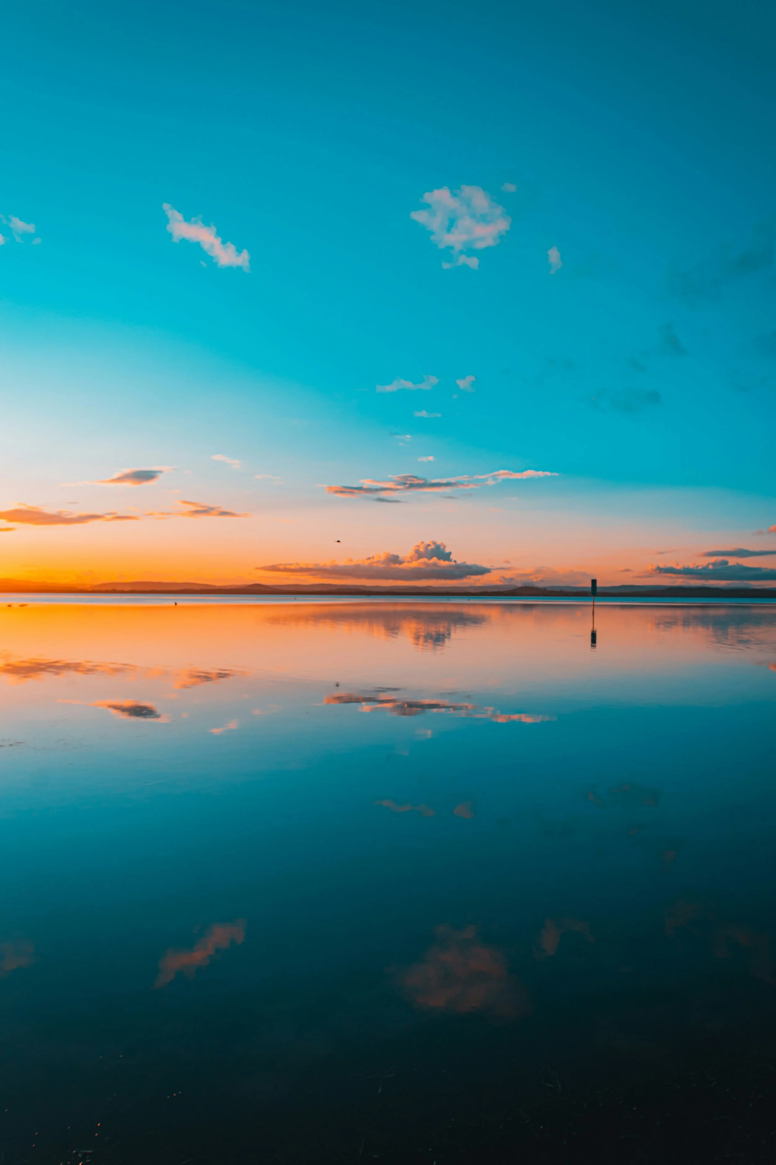 Calm sunset over a still ocean horizon, conveying a sense of peace and hope